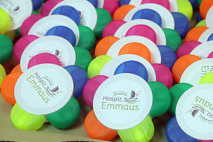 Mehrere bunte Stressbälle mit Aufklebern '25 Jahre Hospiz Emmaus' in einer Anordnung
